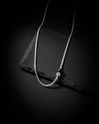 Necklace on a black mannequin bust against a white background