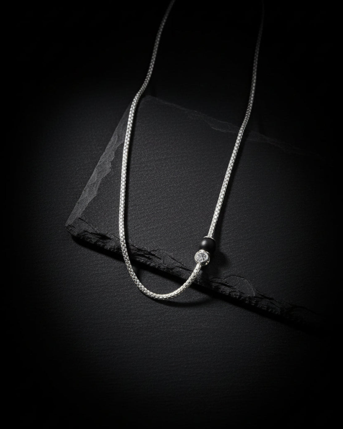 Necklace on a black mannequin bust against a white background