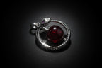 Pendant with red gemstone and silver accents on a white background