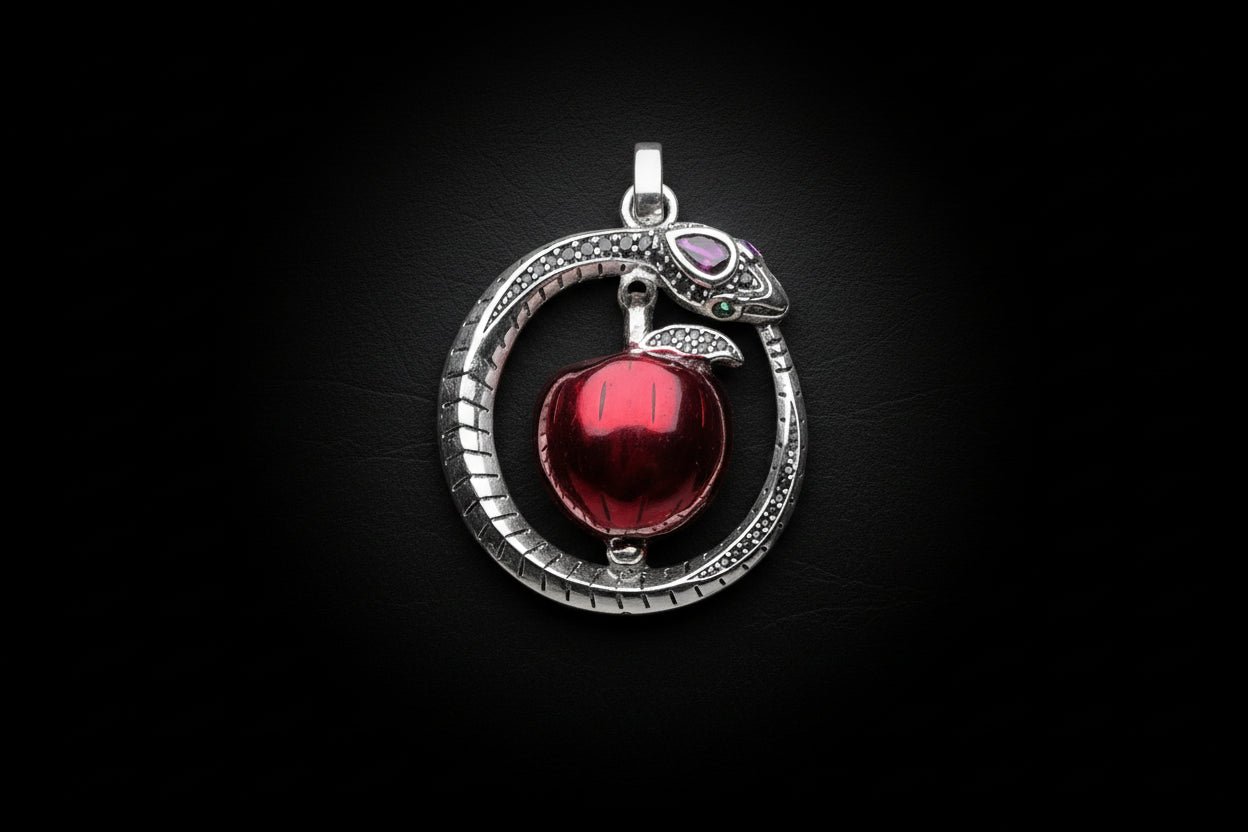Silver pendant with a red apple on a white background.