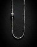 Silver chain necklace on a black textured background