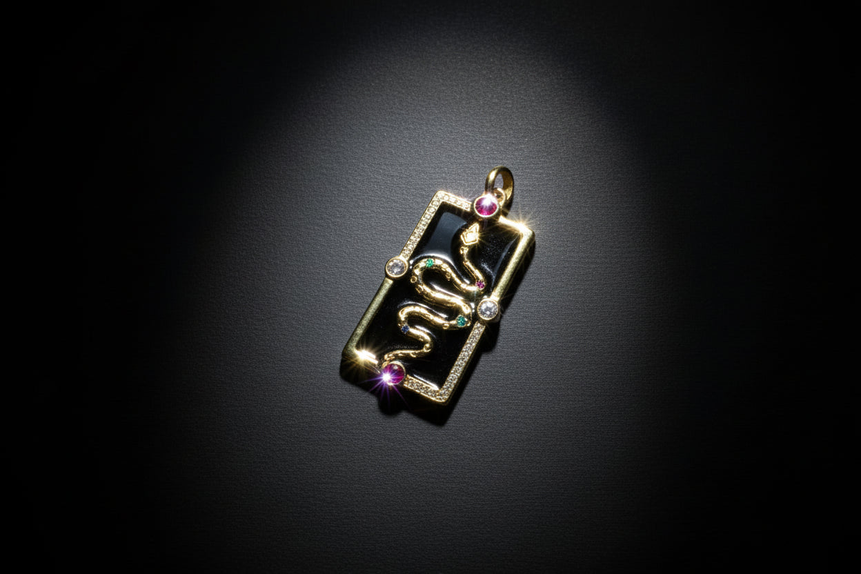 Gold pendant with gemstones on a black background