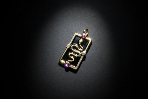 Gold pendant with gemstones on a black background