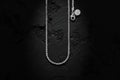 Silver necklace with a pendant on a textured black background
